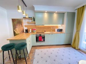 a kitchen with blue cabinets and green stools at Deluxe Suite in Vienna