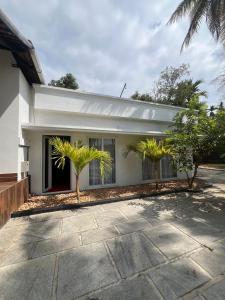 a house with two palm trees in front of it at Vembanad Ripples in Alleppey +38 photos