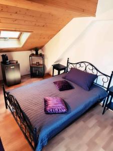 a bedroom with a bed with purple pillows on it at Café des Voyageurs Noës in Chalais