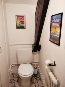 a small bathroom with a toilet and a poster at L'escale Vernonnaise in Vernon