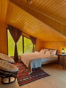 a bedroom with a bed and a large window at Rakursi in Jut'a
