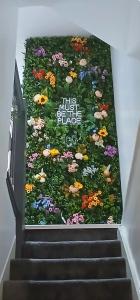 a wall of flowers on the stairs of a building at Seaside Apartment in Moreton