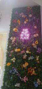 a cake with flowers on it with a neon sign at Seaside Apartment in Moreton