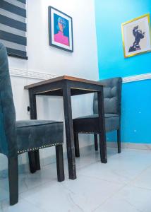 a table and two chairs next to a table and a chair at 3Tee Serviced Apartment Abeokuta in Abeokuta