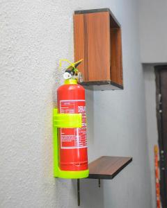a fire extinguisher hanging from a wall next to a fire extinguisher at 3Tee Serviced Apartment Abeokuta in Abeokuta