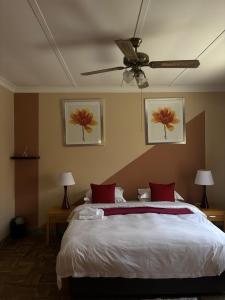 a bedroom with a bed and a ceiling fan at Laroza guest house in Rustenburg