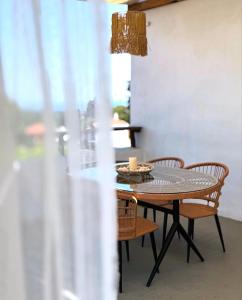 a dining room table with chairs and a chandelier at Chora Suite in Alonnisos