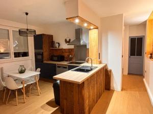 a kitchen with a sink and a table in it at Refuge Éclatant Paray 4 couchages in Paray-le-Monial