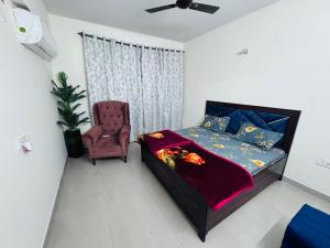 a bedroom with a bed and a chair at Bella Home in Sohāna