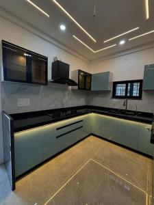 a large kitchen with white cabinets and a sink at Bella Home in Sohāna