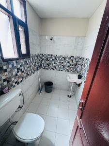 a bathroom with a toilet and a sink at Bella Home in Sohāna