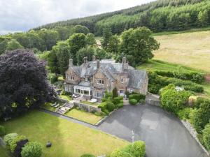 an estate in the hills with a large house at Windlestraw Guesthouse in Walkerburn