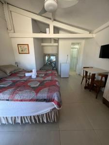 a bedroom with a large bed and a table at Pousada Casa de Praia in Florianópolis