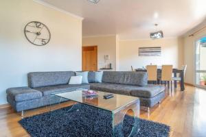 a living room with a couch and a clock on the wall at Vista Calheta Apartment in Calheta