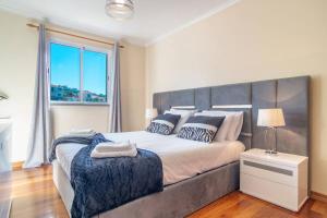 a bedroom with a large bed and a window at Vista Calheta Apartment in Calheta +8 photos