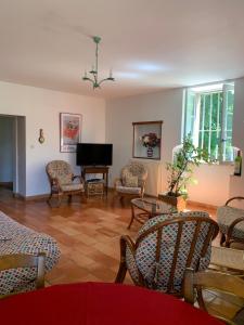 ein Wohnzimmer mit Stühlen und einem Flachbildfernseher in der Unterkunft Loberie in Montvendre