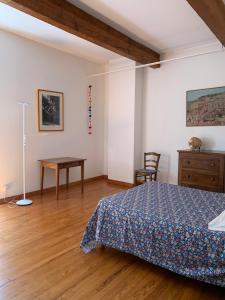 ein Schlafzimmer mit einem Bett, einem Tisch und einem Schreibtisch in der Unterkunft Loberie in Montvendre