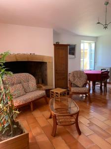ein Wohnzimmer mit Sesseln und einem Kamin in der Unterkunft Loberie in Montvendre