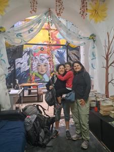 two women and a child posing in front of a painting at Casa CarpeDM in Quito