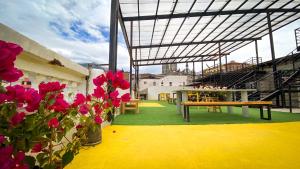 a patio with a table and benches and flowers at Casa CarpeDM in Quito