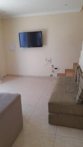 a living room with a flat screen tv on the wall at Casa Costa Azul - praça da Baleia in Rio das Ostras