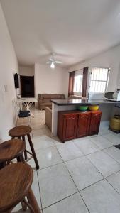 a kitchen with wooden cabinets and tables in a room at Linda Casa Mongagua COM 03 DORMS in Mongaguá