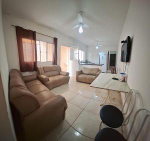 a living room with a couch and a table at Linda Casa Mongagua COM 03 DORMS in Mongaguá
