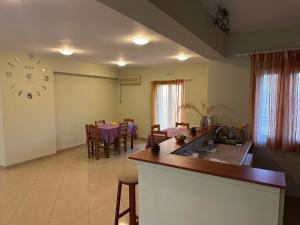 a kitchen and dining room with a large clock on the wall at Evangelia in Agia Effimia
