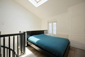 a bedroom with a blue bed in a white room at Charmant Duplex - Hyper Centre - 44m2 - Proche Place Stanislas in Nancy