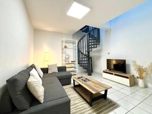 a living room with a couch and a tv at Charmant Duplex - Hyper Centre - 44m2 - Proche Place Stanislas in Nancy