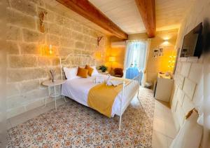 a bedroom with a bed and a table in a room at Ta' Ġilarda Boutique Living in Birbuba +62 photos