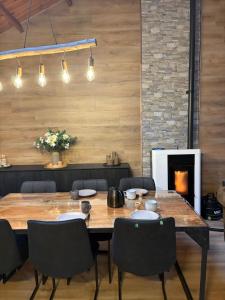 a dining room with a table and chairs and a fireplace at Chalet La Vallée La Boverie in Rendeux