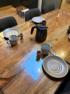 a wooden table with plates and a tea pot on it at Chalet La Vallée La Boverie in Rendeux