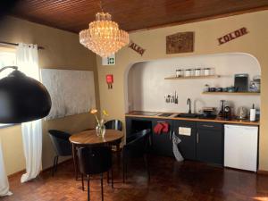 a kitchen with a table and chairs and a chandelier at Casa-Stella-Azores in Capelas +19 photos