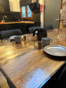 a wooden table with two cups and plates on it at Chalet La Vallée La Boverie in Rendeux