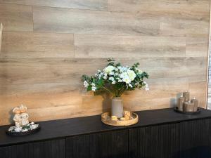 a vase of flowers on a table with candles at Chalet La Vallée La Boverie in Rendeux +41 photos