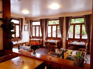 a dining room with tables and chairs and windows at Café des Voyageurs Noës in Chalais