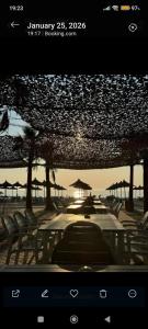 a view of a beach with chairs and tables and umbrellas at Hydrovor Apartment & Room in Hamallë