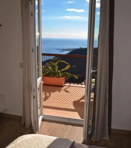 an open door to a balcony with a view of the ocean at Tao enJoy Suite in Taormina