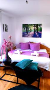 a bedroom with a large bed with purple pillows at FeWo Sartorius am Hemsberg in Bensheim