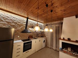 a kitchen with white appliances and wooden ceilings at Blue Sea Suite Avlakia in Avlákia