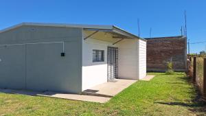 a white garage with a door in a yard at Nyumba in Colonia Nuevo Paysandú