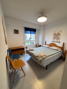 a bedroom with a bed and a chair and a window at Urbanova apartamento in El Alted
