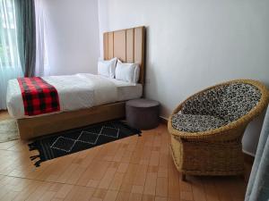a bedroom with a bed and a chair at Mara Balanite Hotel in Masai Mara