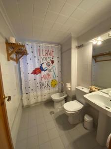a bathroom with a toilet and a shower curtain at Urbanova apartamento in El Alted +13 photos