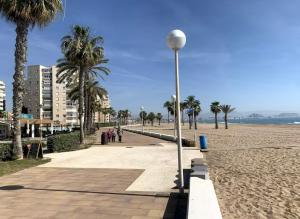 a street light next to a beach with palm trees at Urbanova apartamento in El Alted