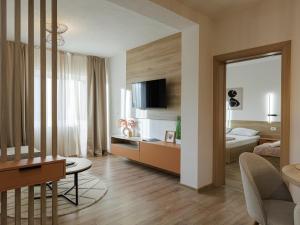 a living room with a room with a bed and a desk at Avenue Apartments Ilinden in Ilinden