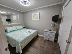 a small bedroom with a bed and a night stand at BEACHSIDE CONDO-WATER AND POOL VIEW Top Floor in Tybee Island