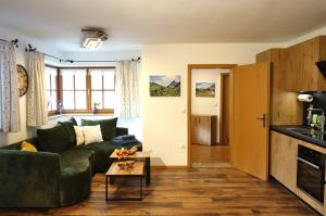 a living room with a green couch and a table at Ferienwohnungen Vogelrast in Berchtesgaden +14 photos