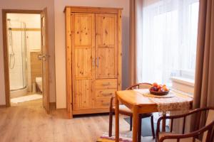 a dining room with a table and a wooden cabinet at Zubrzyckie Pokoje in Zubrzyca Dolna +15 photos